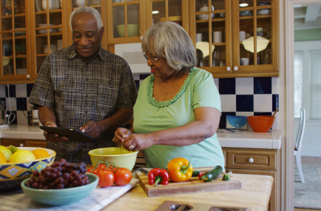 A senior couple making a healthy lunch in the kitchen together.