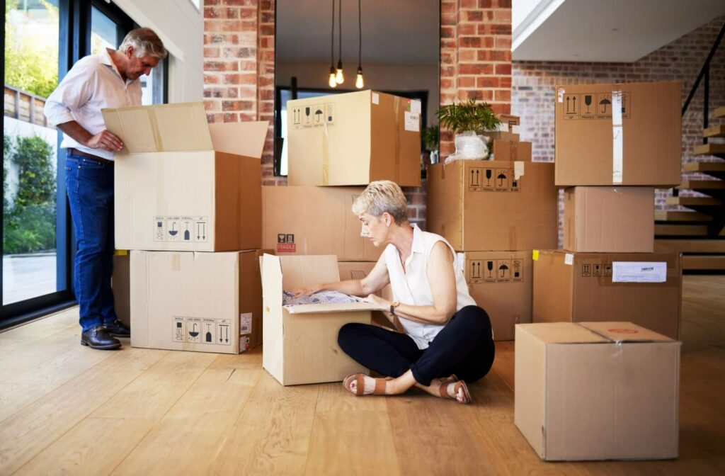 A senior couple works together to pack boxes for their move into independent living