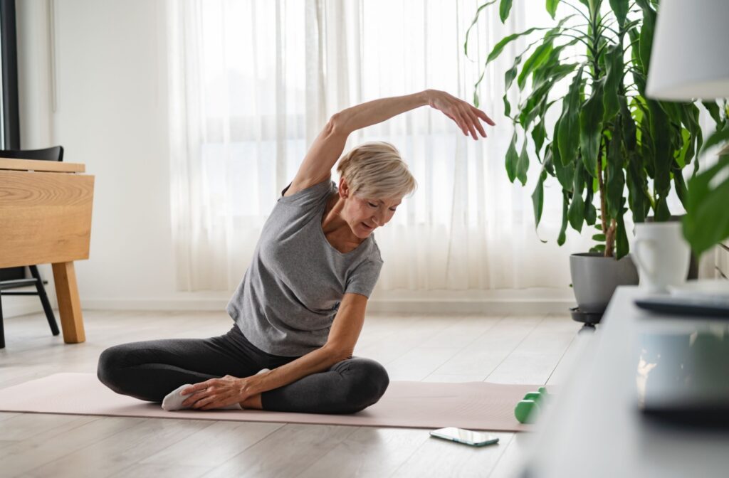 A senior woman doing seated yoga as a posture exercise to improve her flexibility.