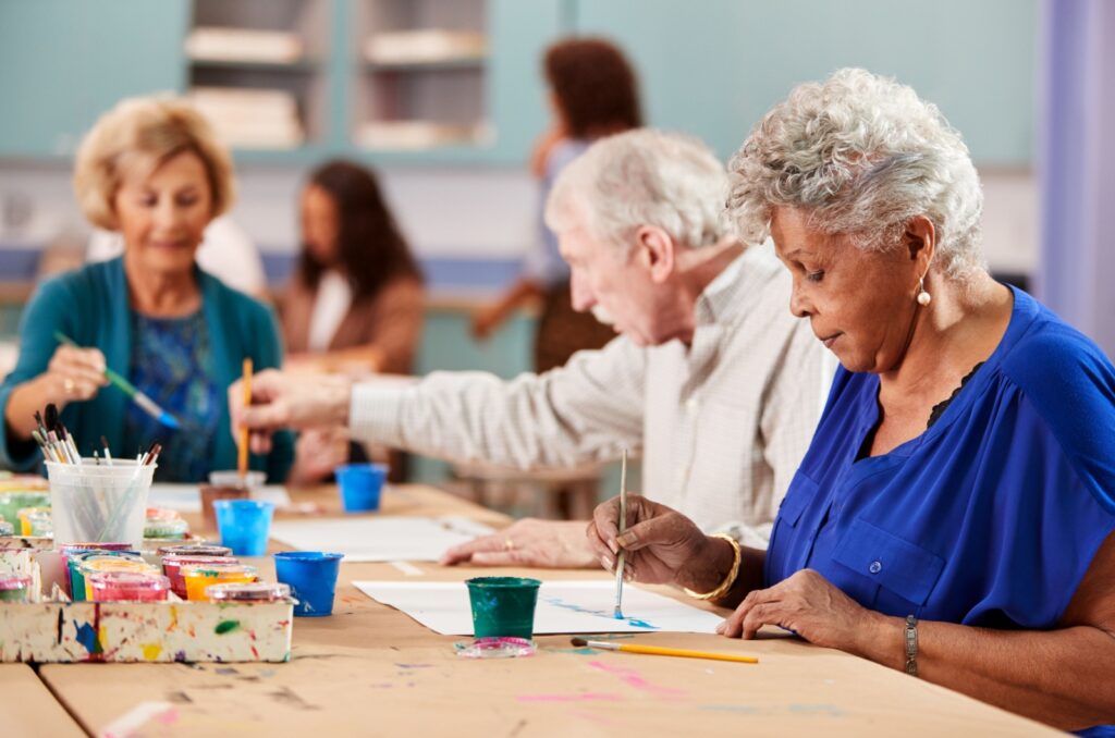 A group of older adults painting in an art class.