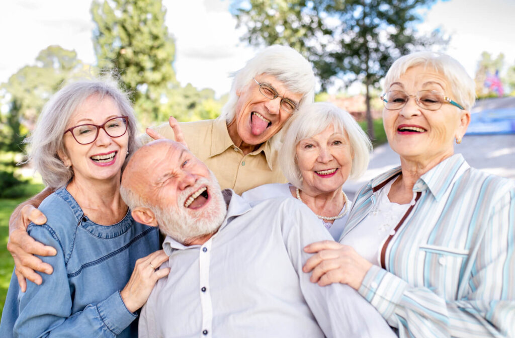A group of older adults making silly faces together during a trip outside in assisted living.