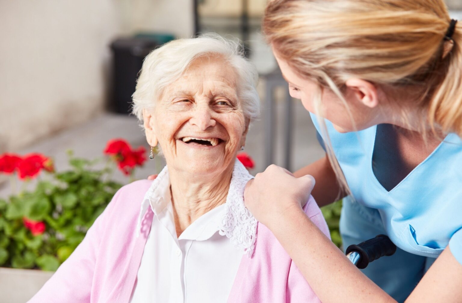a senior smiling to a caregiver in assisted living